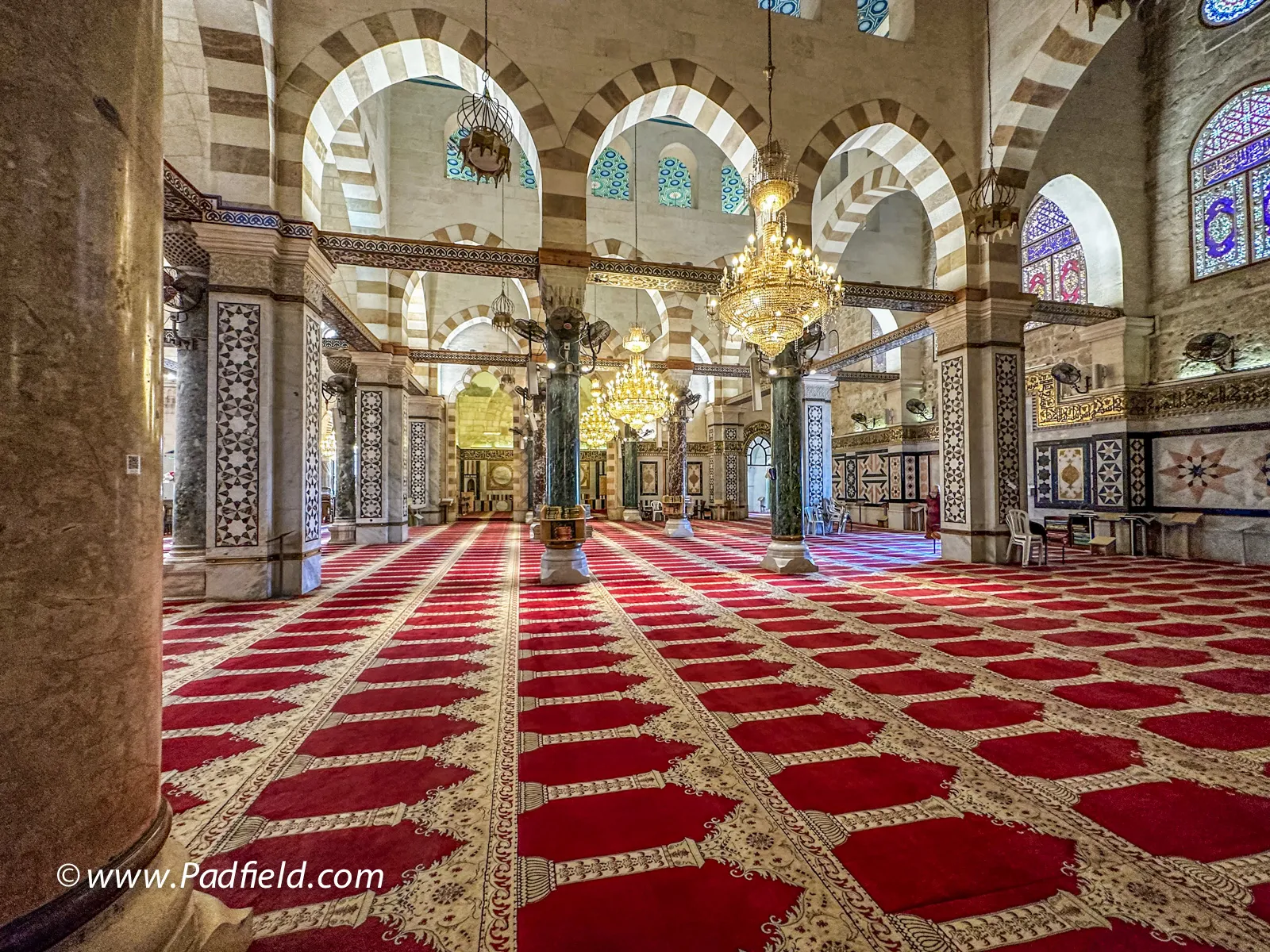 Mosque interior with red carpet and arches